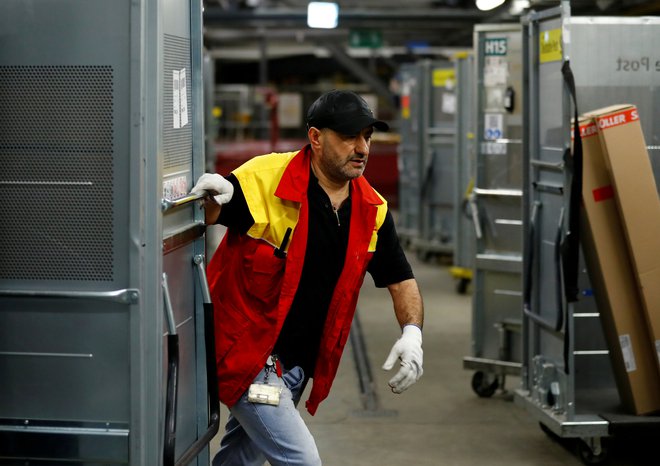 Nemški poštarji bodo dobili 300 evrov dodatka za delo med pandemijo. FOTO: Ralph Orlowski/Reuters