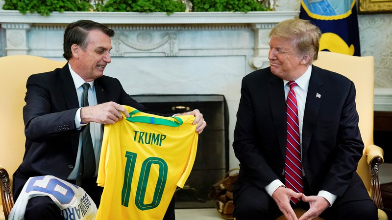 Fotografija: Brazilski predsednik Jair Bolsonaro in njegov ameriški kolega Donald Trump sta včerajšnji obisk ozaljšala z izmenjavo nogometnih majic. Trump je dobil Peléjevo desetico. FOTO: Reuters