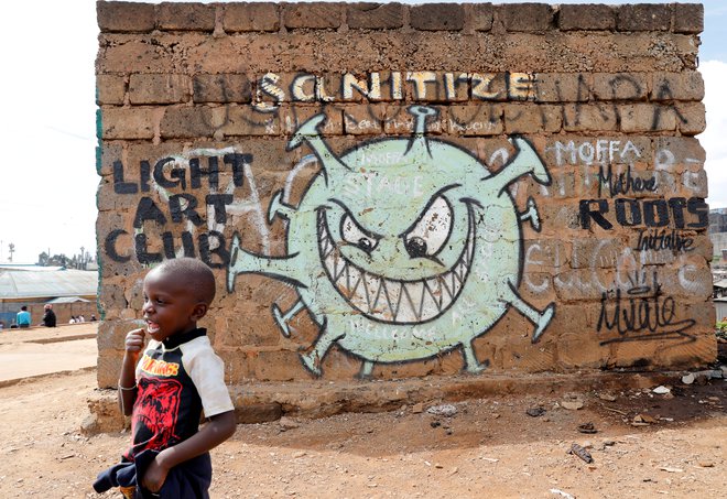 Grafit v barakarskem naselju Mathare v Nairobiju opozarja na virus. FOTO: Baz Ratner/Reuters