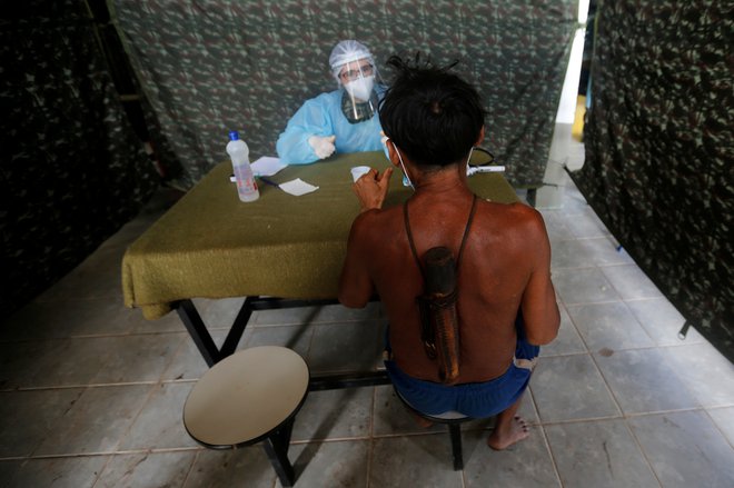 Vojaški zdravnik pregleduje člana etnične skupine Yanomami. FOTO: Adriano Machado/Reuters