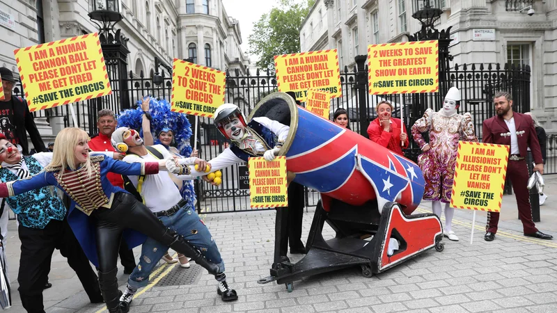 Fotografija: Cirkuški izvajalci so se iz Downing Streeta v Londonu podali na Trg Parliament, potem ko so predsedniku vlade predali pismo, v katerem pozivajo, da se na višku poletne sezone cirkusi ponovno odprejo. FOTO: Isabel Infantes/Afp