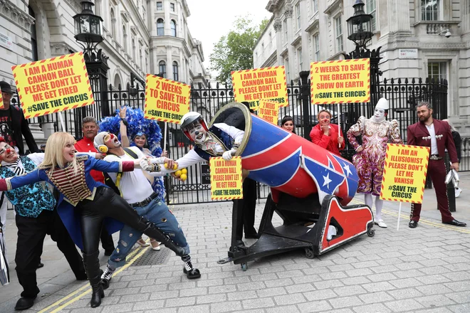Cirkuški izvajalci so se iz Downing Streeta v Londonu podali na Trg Parliament, potem ko so predsedniku vlade predali pismo, v katerem pozivajo, da se na višku poletne sezone cirkusi ponovno odprejo. FOTO: Isabel Infantes/Afp