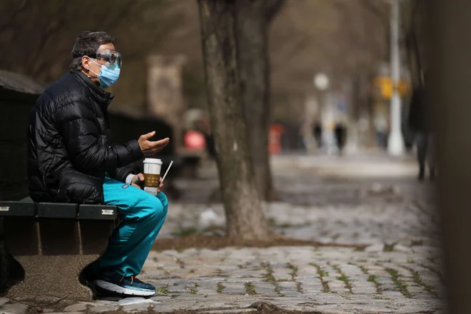 Zdravstveni delavec na oddihu pred bolnišnico Mount Sinai v New Yorku. Tudi v bolnišnicah v New Yorku, epicentru epidemije v ZDA, vlada pomanjkanje postelj, ventilatorjev in zaščitne opreme. FOTO: Spencer Platt/AFP
