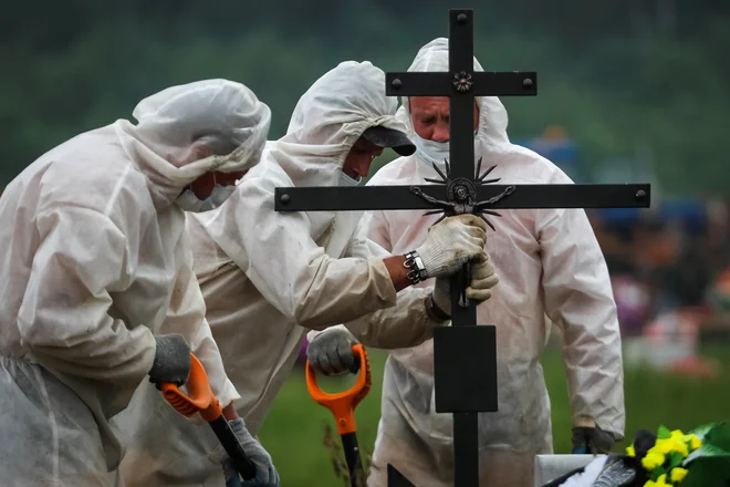 Matematik Mihail Tamm, docent na moskovski državni univerzi, se že od izbruha epidemije redno ukvarja z analizami uradnih statistik. Po njegovem je pravo število mrtvih vsaj za 60 odstotkov večje od uradno objavljenih podatkov. Na fotografiji: pogreb blizu Sankt Peterburga FOTO: Anton Vaganov/Reuters