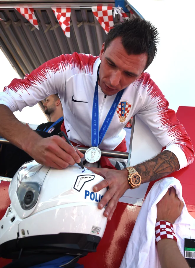 Nogometaš Mario Mandžukić med podpisovanjem avtograma. FOTO: Attila Kisbenedek/AFP