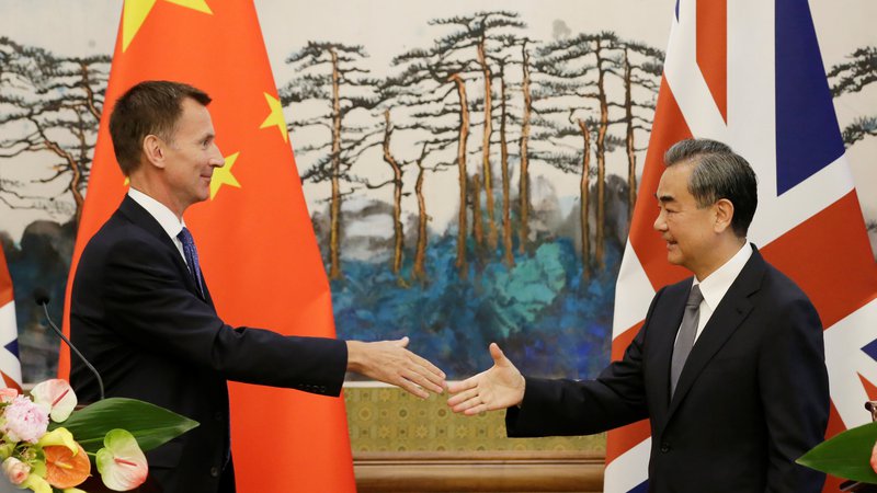 Fotografija: Kitajski zunanji minister Wang Yi si ni vzel k srcu prvega spodrsljaja britanskega zunanjega ministra Jeremyja Hunta (levo). FOTO: Reuters