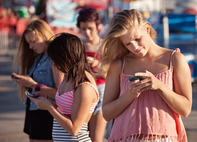 Gledanje v mobilni telefon med hojo ni prekršek, je pa lahko nevarno ravnanje. FOTO: Shutterstock