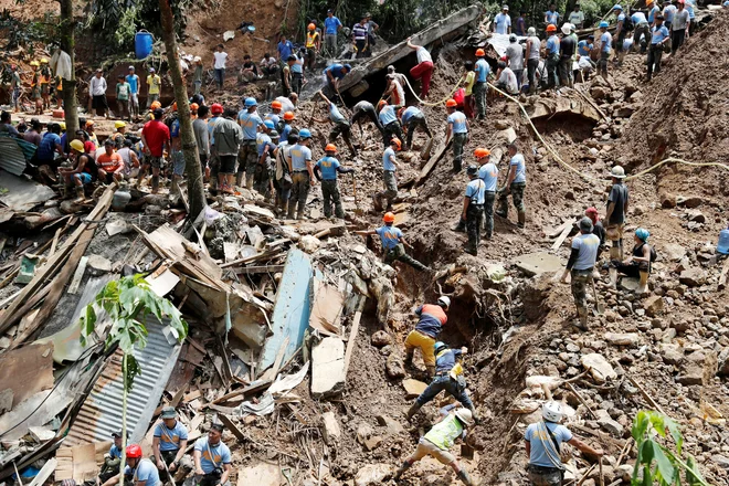 Reševalci iščejo preživele rudarje na Filipinih, kjer je rudnik zasul zemeljski plaz. FOTO: Erik De Castro/Reuters