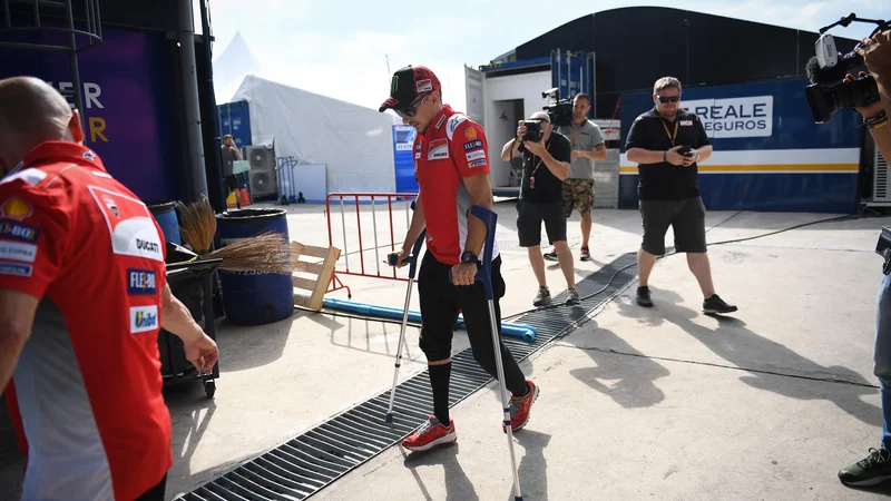 Fotografija: Jorge Lorenzo si je ob prihodu v Buriram še pomagal z berglami. FOTO: Lillian Suwanrumpha/AFP