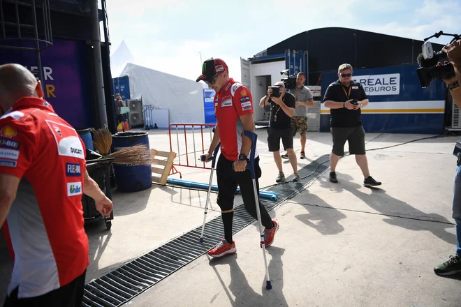 Jorge Lorenzo si je ob prihodu v Buriram še pomagal z berglami. FOTO: Lillian Suwanrumpha/AFP