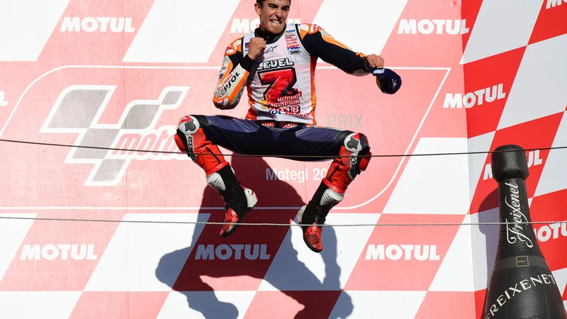 Fotografija: Marc Marquez si je po osvojitvi naslova prešerno dal duška v Motegiju. FOTO: AFP