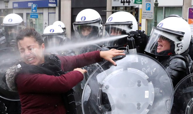 Policija se je nad protestnico v Bruslju znesla s solzivcem.  FOTO: Yves Herman/Reuters
