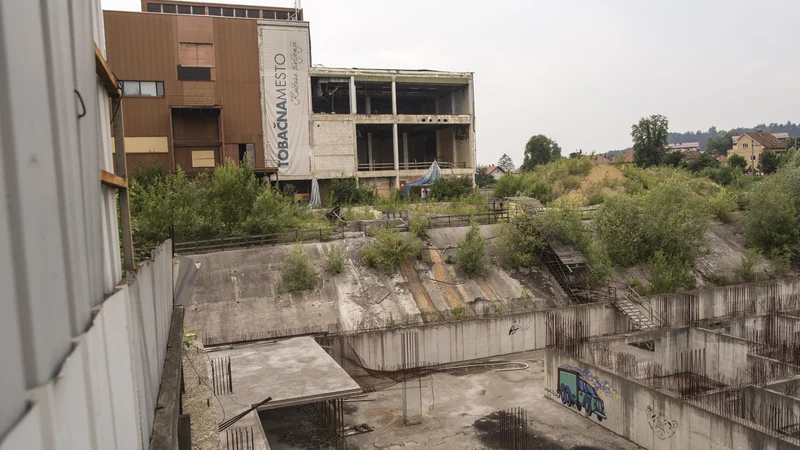 Fotografija: Gradbena jama na območju Tobačne bo zevala še najmanj pol leta. Usoda prodaje nepremičnin propadlega Imosa-G je zdaj v rokah ustavnih sodnikov. Foto Voranc Vogel