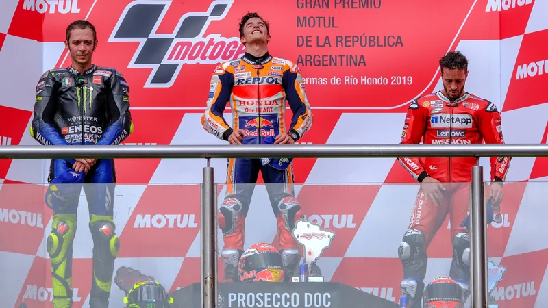 Fotografija: Andrea Dovizioso (desno) je tudi med razglasitvijo mrko držal ob Valentinu Rossiju (levo) in Marcu Marquezu. FOTO: Reuters