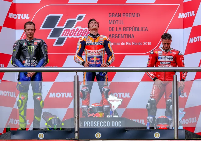 Andrea Dovizioso (desno) je tudi med razglasitvijo mrko držal ob Valentinu Rossiju (levo) in Marcu Marquezu. FOTO: Reuters