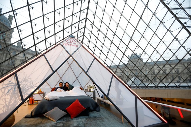 Tridesetletnico piramide so zaznamovali tudi tako, da je Airbnb ponudil »noč v Louvru«. FOTO: Charles Platiau/Reuters