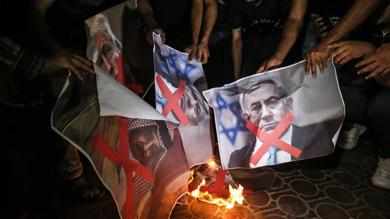Fotografija: Palestinci v južni Gazi so v znak nestrinjanja s »priložnostjo stoletja«, kot je načrt poimenoval Jared Kushner, zažgali plakate s podobami ameriškega predsednika Trumpa, izraelskega premiera Netanjahuja in kralja Bahrajna Hamada al-Kalife. Foto: Said Khatib AFP