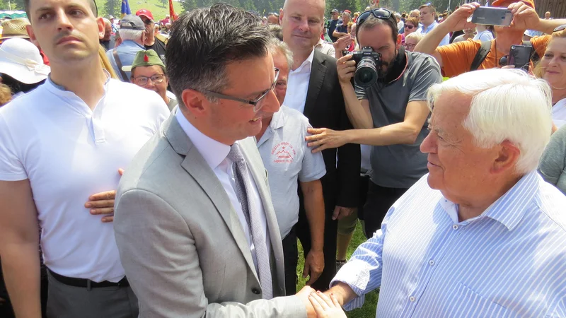 Fotografija: Tovariški stisk rok predsednika vlade Marjana Šarca in prvega predsednika Slovenije Milana Kučana. FOTO: Bojan Rajšek/Delo