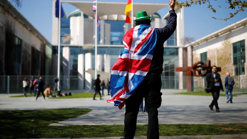 Fotografija: Osamljeni protestnik pred poslopjem kanclerske palače v Berlinu zbuja vtis, da Nemci niso zelo zaskrbljeni zaradi negativnih posledic, ki jih bo brexit prinesel njihovemu gospodarstvu. Foto Reuters