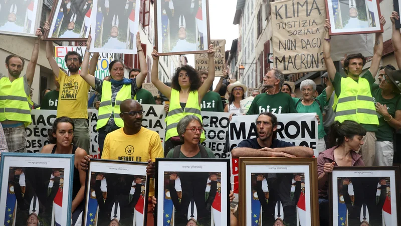 Fotografija: Demonstranti v mestu Bayonne z na glavo obrnjenimi fotografijami francoskega predsednika. Ko so se demonstracije razvnele, je policija razgnala protestnike z vodnimi topovi in solzivcem. FOTO: Reuters