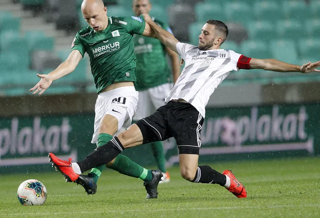 Ljubljančani so po hudem boju z desetimi igralci, potem ko je bil v 78. minuti izključen Tomislav Tomić (levo), le prišli do pete prvenstvene zmage. Kapetan Mure Alen Kozar (desno) pa je prvič v sezoni okusil grenkobo poraza. FOTO: Mavric Pivk/Delo