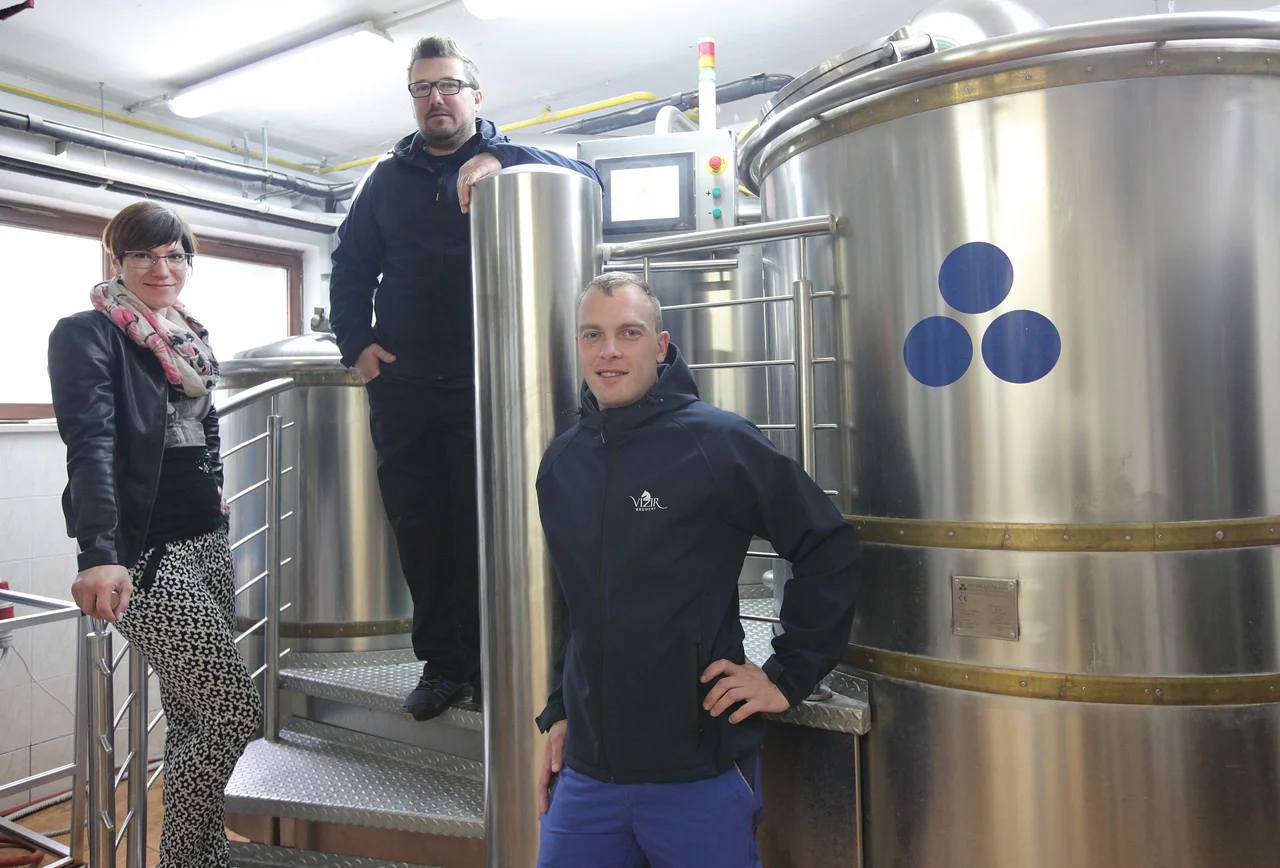 Fotografija: Tri četrtine Vizirjeve ekipe (manjka solastnik Denis Imširović) – Maja Imširović, varilec in vodja proizvodnje Peter Geltar ter varilec in komercialist Stanislav Nemanič ob kuhinji za pivo. FOTO: Mavric Pivk