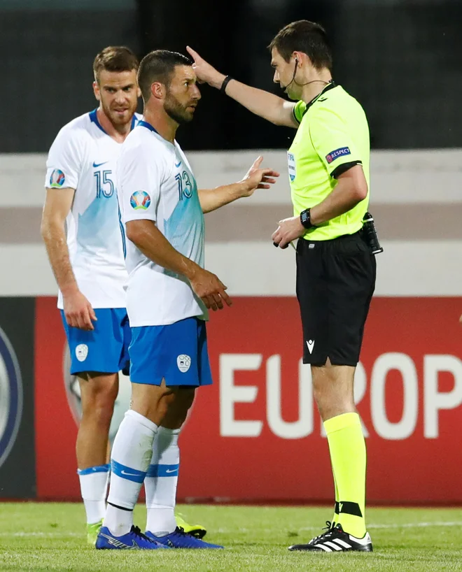 Bojan Jokić med pogovorom s sodnikom Kevinom Clancyjem na gostovanju v Rigi. FOTO: Reuters