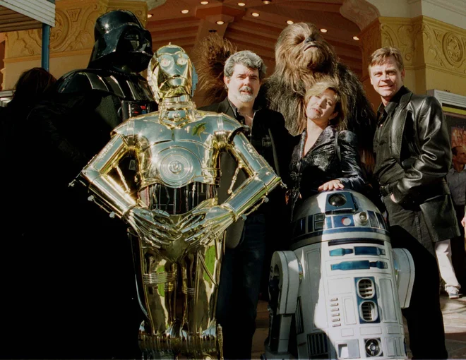 Ekipa prve Vojne zvezd (brez Harrisona Forda) dvajset let po prvem filmu – (na fotografiji z leve) Darth Vader, C-3PO, George Lucas, Chewbacca, princesa Leia Organa (Carrie Fisher), Luke Skywalker (Mark Hamill) in (spodaj) in R2-D2. FOTO: Reuters
