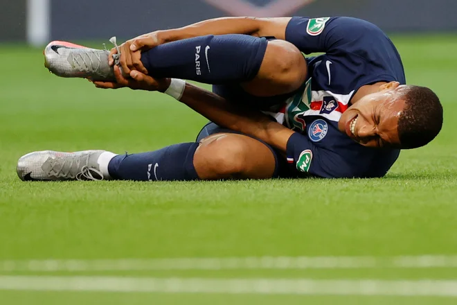 Kylian Mbappé se je po grobem prekršku Loica Perrina zvijal od bolečin. FOTO: Christian Hartmann/Reuters