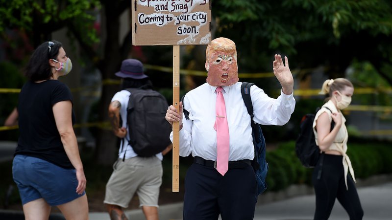 Fotografija: Protestnik v prestolnici Washington z masko predsednika Trumpa. Foto Olivier Douliery Afp