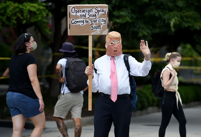 Protestnik v prestolnici Washington z masko predsednika Trumpa. Foto Olivier Douliery Afp
