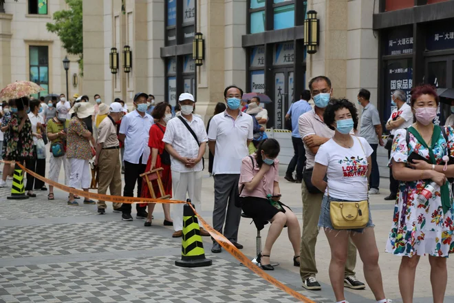 Prebivalci Daliana med čakanjem na testiranje za koronavirus. FOTO: STR/AFP