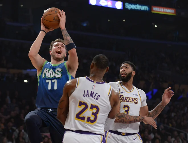 Luka Dončić (77) je v tej sezoni že dokazal, da se prav nič ne boji LeBrona Jamesa (23) in Anthonyja Davisa (3). FOTO: Reuters