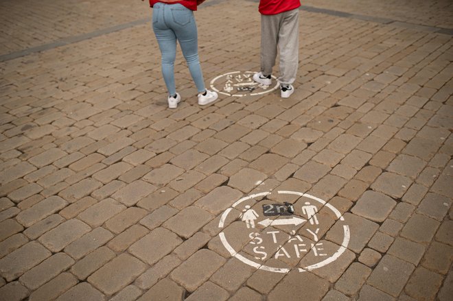 V Veliki Britaniji obnavljajo oznake za vzdrževanje razdalje med nakupovalci. FOTO: Oli Scarff/AFP