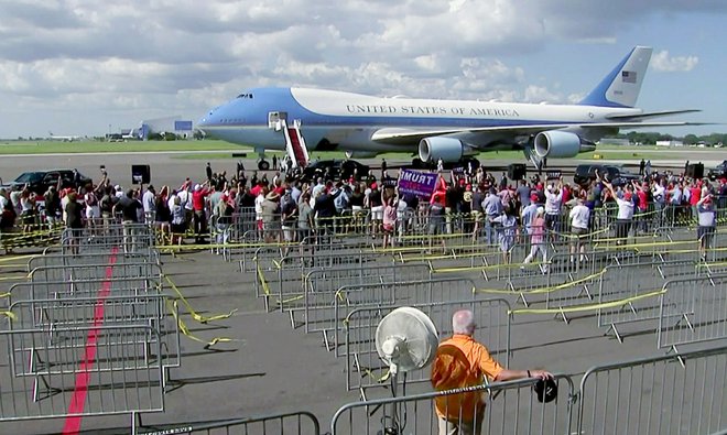 Trump pozdravlja privržence po priletu na floridsko letališče v Tampi. Foto Pool Pool Via Reuters