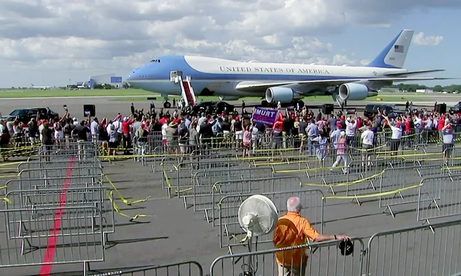 Trump pozdravlja privržence po priletu na floridsko letališče v Tampi. Foto Pool Pool Via Reuters