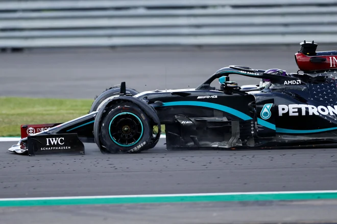 Lewis Hamilton se je v cilj pripeljal s počeno gumo. FOTO: Andrew Boyers/AFP
