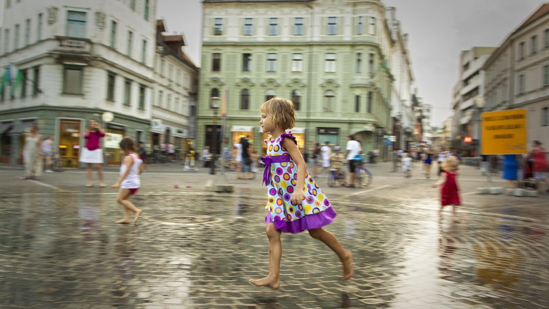Fotografija: Na Prešernovem trgu v Ljubljani, kjer se v umetnem dežju lahko ljudje malo ohladijo. Foto Voranc Vogel