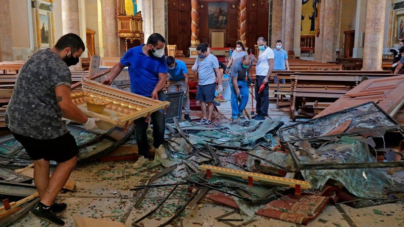 Fotografija: Tudi sakralna arhitektura v Bejrutu je poškodovana. V maronitski cerkvi svetega Jurija so takole reševali opremo. Foto Joseph Eid/AFP