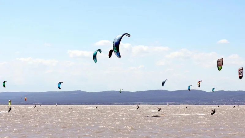 Fotografija: Jezero je zelo, zelo priljubljeno središče za vodne športe, zaradi stalnega in močnega vremena slovi kot raj za kajtarje, surferje, tudi kopalcev ne manjka. FOTO: Dušan Dundek