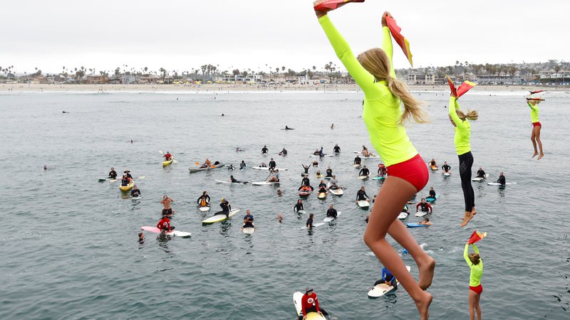 Fotografija: Mladi udeleženci programa za reševalce iz vode (San Diego Junior Lifeguard) skačejo s pomola na letnem obredu v Ocean Beachu v Kaliforniji. FOTO: Mike Blake/Reuters