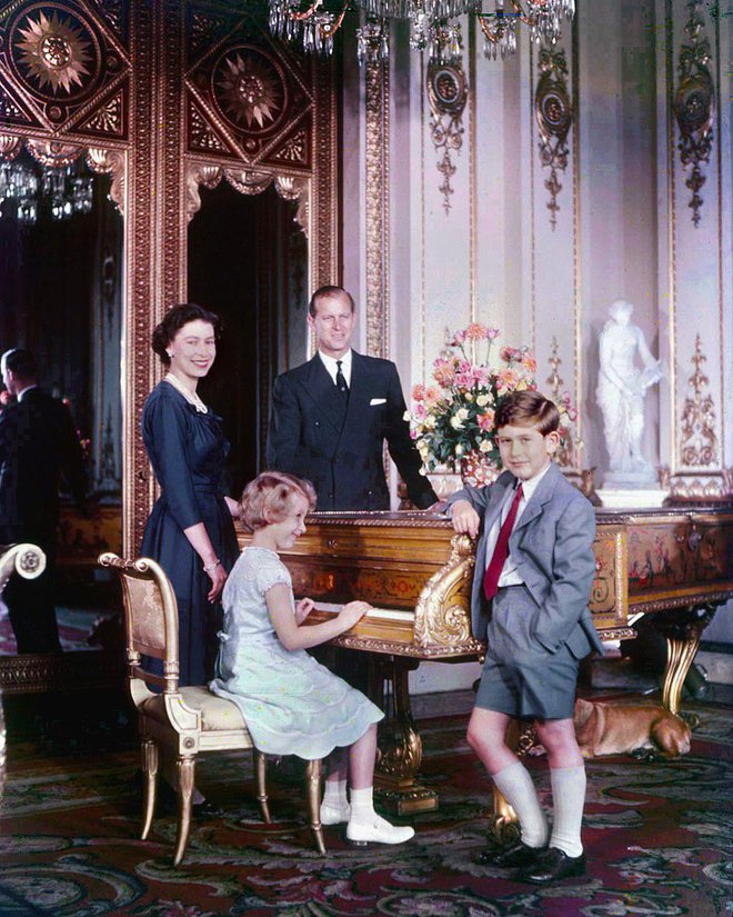 Princesa Ana za klavirjem v družbi starejšega brata Charlesa s staršema oktobra 1957. Foto Wikipedija