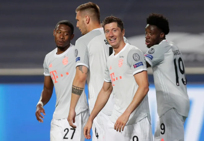 Najmlajši &raquo;Bavarec&laquo; na igrišču Alphonso Davies (desno) si je od starejših soigralcev in nestorjev v slačilnici, kot je Robert Lewandowski, prislužil čestitke. FOTO: Pool Reuters