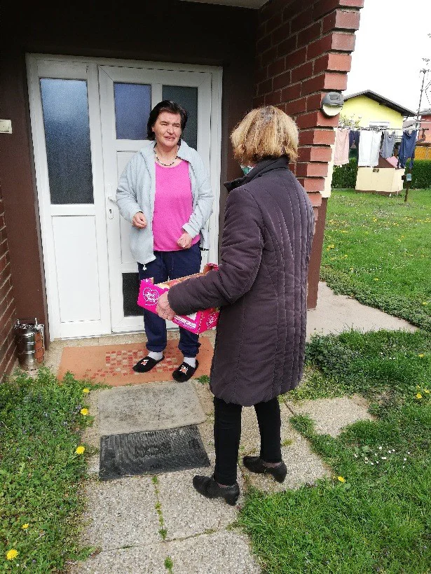 Slava Zorc s škatlo sadja pred domom uporabnice na Ptuju. FOTO arhiv Zifsa