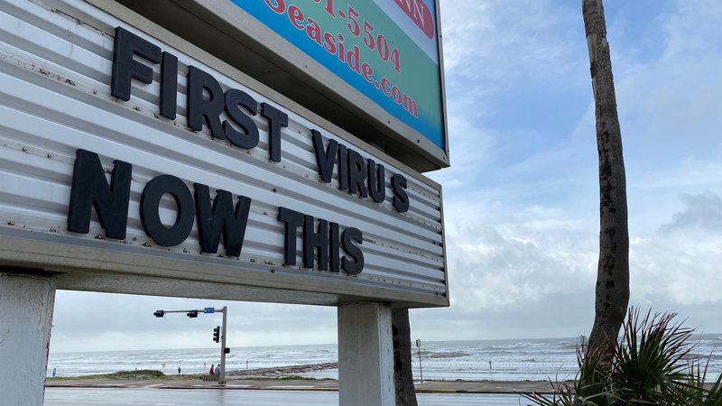 Fotografija: Znak, ki se sklicuje na koronavirusno bolezen in orkan Laura v kraju Galveston v Teksasu. FOTO: Julio Cesar Chavez/Reuters