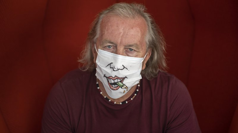 Fotografija: Marko Kočevar s času primerno karikaturo na zaščitni maski.        FOTO: Voranc Vogel/Delo
