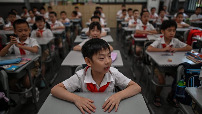 Fotografija: Skoraj 1,4 milijona učencev v več kot 2840 osnovnih in srednjih šolah v Wuhanu je šlo v torek skozi novo šolsko proceduro. Foto: Hector Retamal/Afp