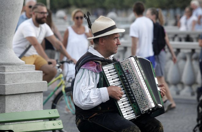 Harmonikar na Tromostovju je marsikomu trn v peti. FOTO: Mavric Pivk/Delo