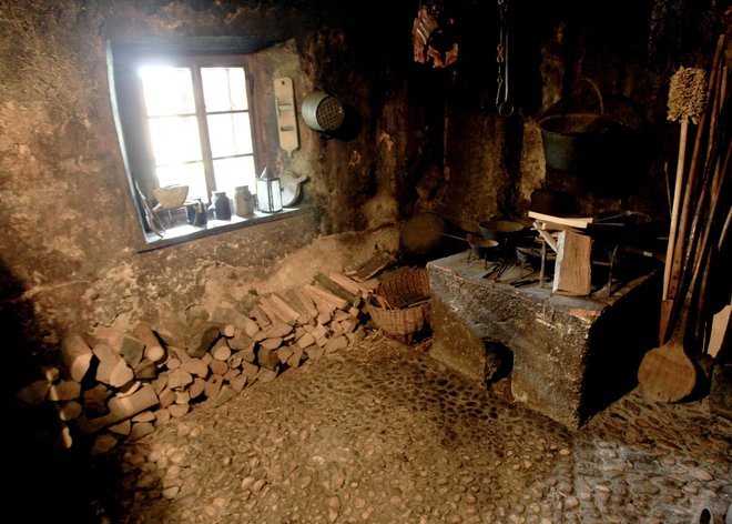 V črni kuhinji je odprto ognjišče in kurišče za kmečko peč, ki stoji v hiši, tako da je ta ostala čista. FOTO: Roman Šipić