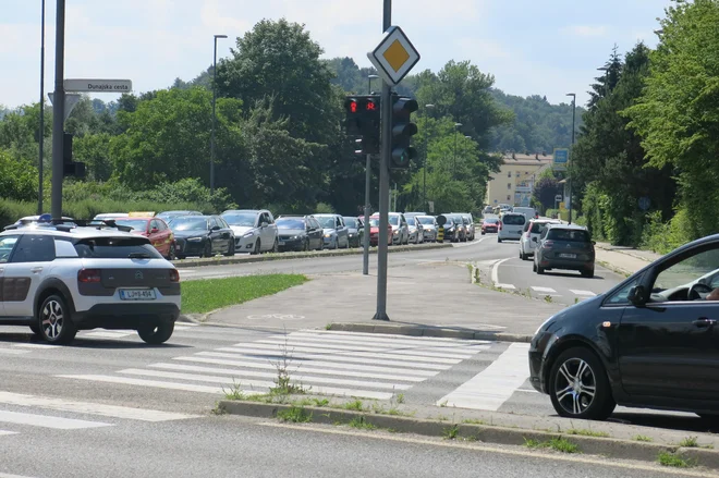 V križišču Dunajske in Štajerske ceste na koncu Črnuč imajo vsi, ki zavijajo proti Trzinu, v popoldanskih konicah velike težave, saj je interval na semaforju prekratek. Zato nastajajo kolone vse do cerkve. FOTO: Janez Petkovšek